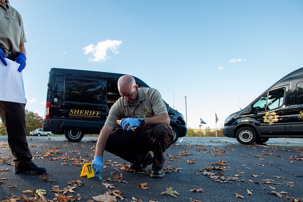 Crime Scene Technician placing evidence tent